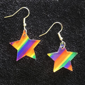 A pair of star-shaped earrings with rainbow stripes in red, orange, yellow, green, blue, and purple, displayed on a black textured background. The earrings have gold hooks.
